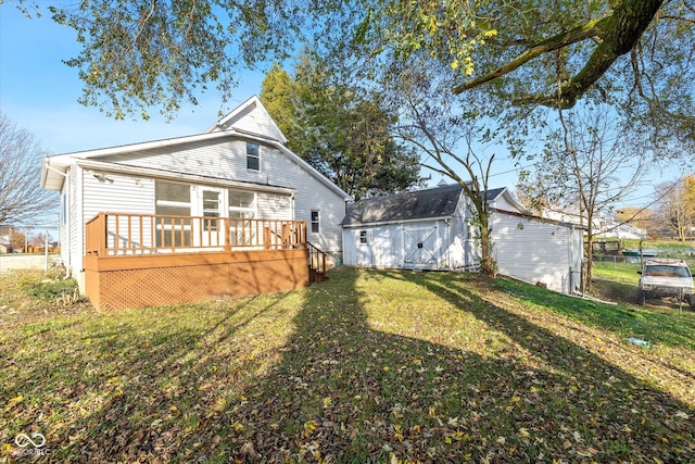 back of house featuring a lawn and a wooden deck