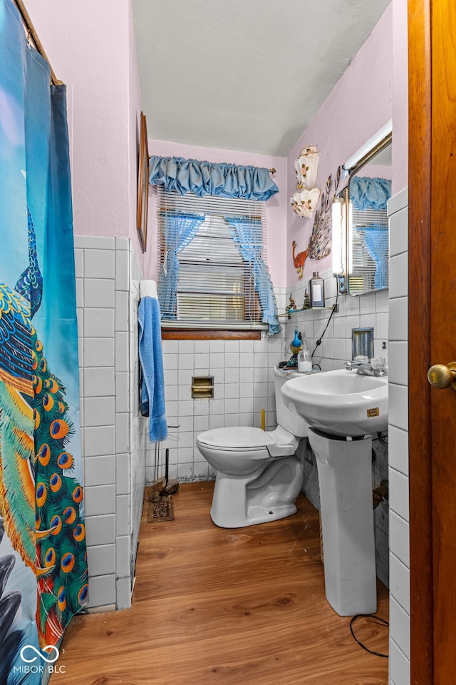 bathroom featuring tile walls, wood-type flooring, and toilet