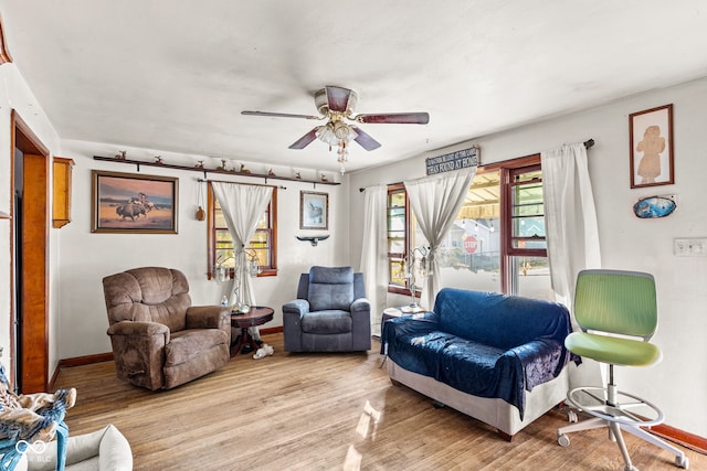 living room with light hardwood / wood-style flooring, a barn door, and ceiling fan