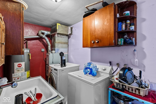 laundry room featuring sink, washer and dryer, cabinets, and water heater