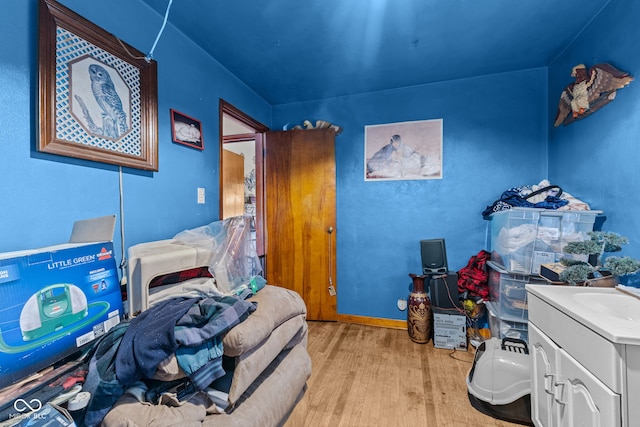 bedroom with light hardwood / wood-style floors and sink