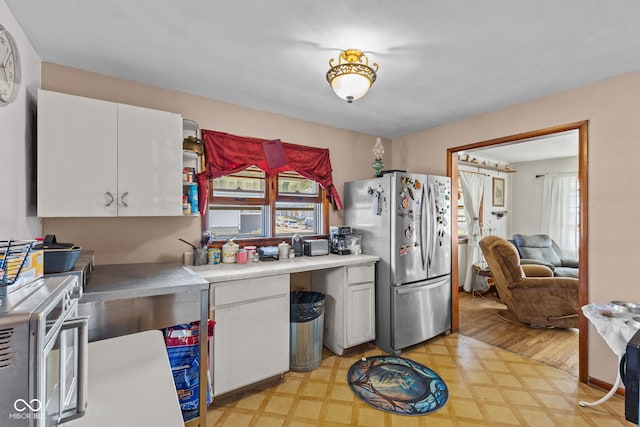 kitchen featuring appliances with stainless steel finishes, light hardwood / wood-style flooring, and white cabinets