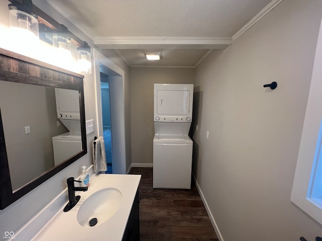 bathroom with hardwood / wood-style floors, sink, stacked washer and clothes dryer, a textured ceiling, and ornamental molding