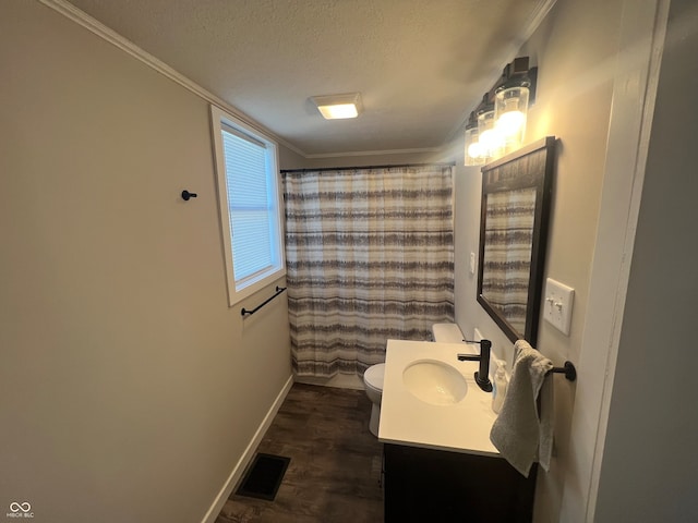 bathroom featuring a textured ceiling, vanity, toilet, hardwood / wood-style flooring, and crown molding