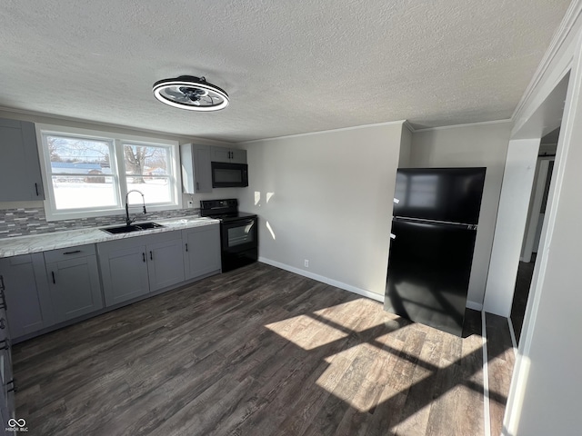 kitchen featuring gray cabinetry, dark hardwood / wood-style floors, a textured ceiling, black appliances, and sink