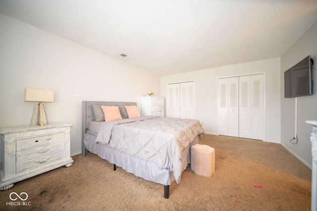 carpeted bedroom featuring two closets