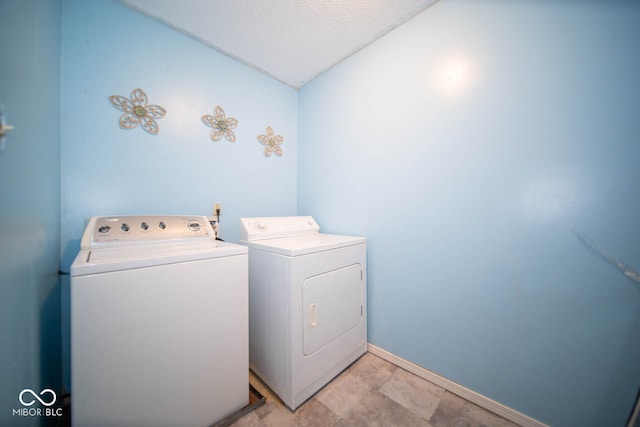 laundry area featuring washer and clothes dryer and a textured ceiling