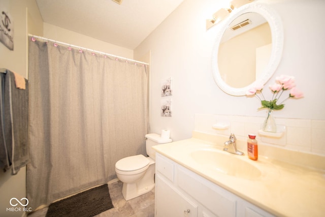 bathroom featuring curtained shower, vanity, and toilet