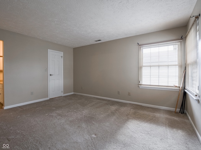 unfurnished room featuring carpet flooring and a textured ceiling