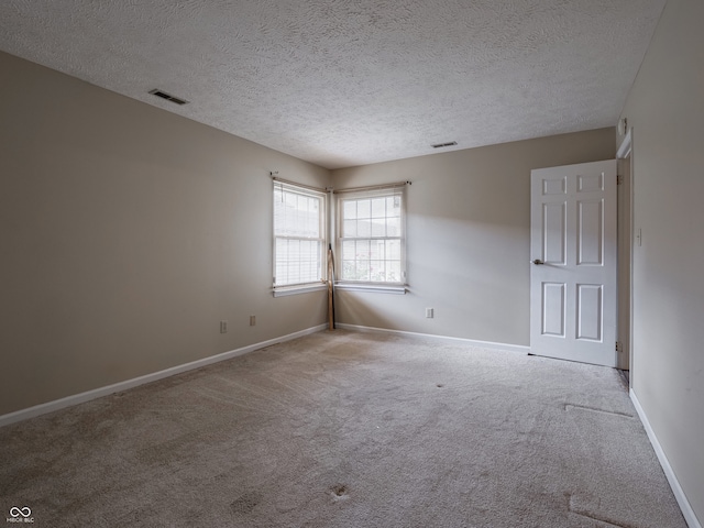 carpeted spare room featuring a textured ceiling