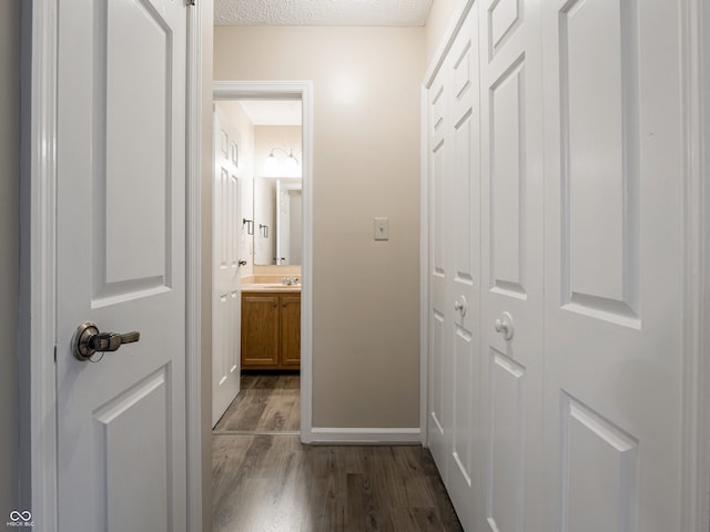 corridor with dark wood-type flooring and a textured ceiling