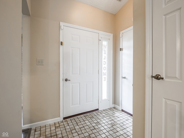 tiled entrance foyer featuring a textured ceiling