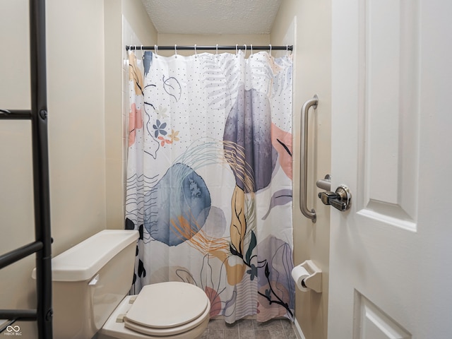 bathroom featuring a textured ceiling and toilet