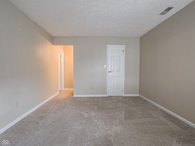 carpeted empty room featuring a textured ceiling