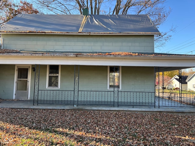 rear view of house featuring covered porch