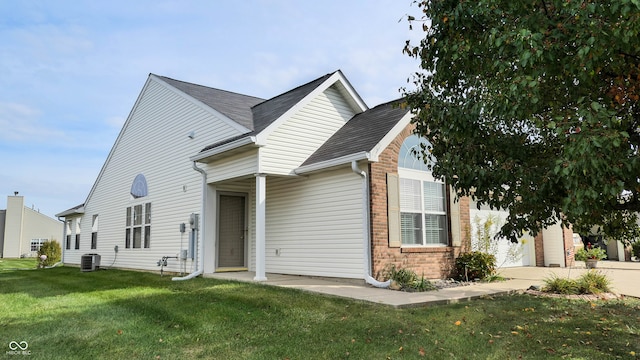 view of front of house with a front lawn and central AC unit