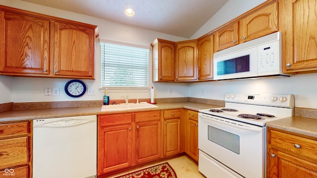 kitchen with sink, vaulted ceiling, and white appliances