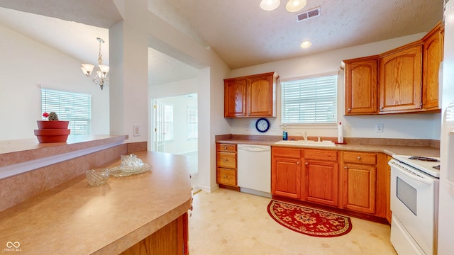 kitchen with white appliances, lofted ceiling, sink, and plenty of natural light