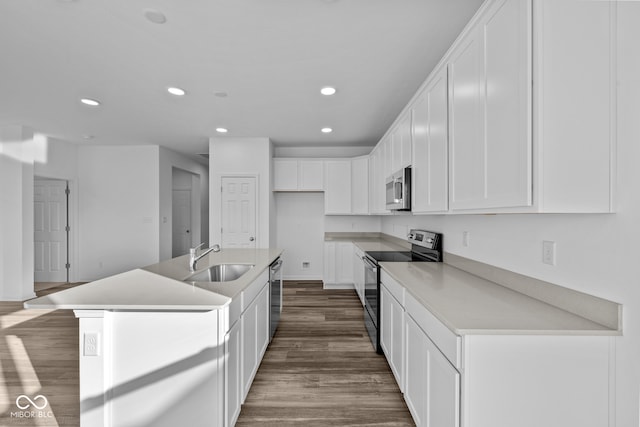 kitchen featuring stainless steel appliances, dark hardwood / wood-style flooring, sink, an island with sink, and white cabinets