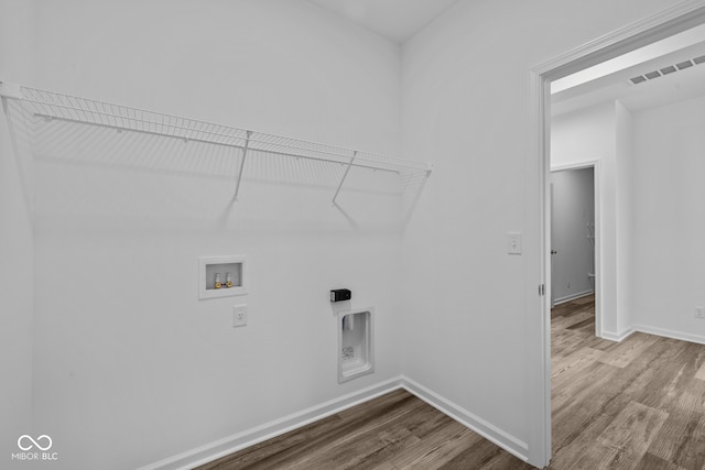 laundry area featuring wood-type flooring, hookup for a washing machine, and electric dryer hookup