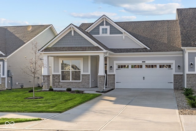 craftsman-style house featuring a garage, a porch, and a front yard