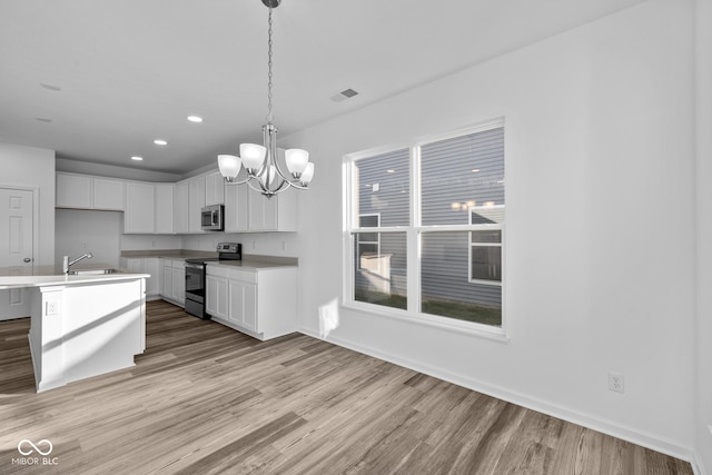 10549 Maidenhair Dr, Indianapolis, IN 46239 - kitchen featuring stainless steel appliances, light wood-style flooring, a chandelier, white cabinetry, and recessed lighting