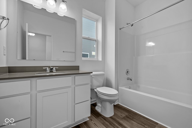 full bathroom featuring vanity, hardwood / wood-style flooring, tub / shower combination, and toilet