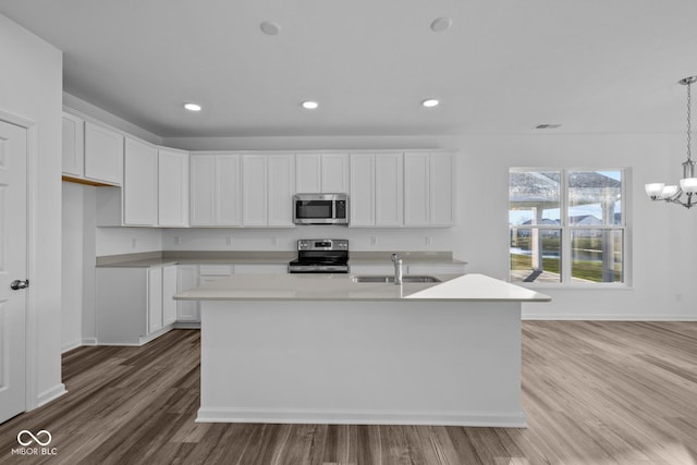 10549 Maidenhair Dr, Indianapolis, IN 46239 - kitchen with stainless steel appliances, a sink, light wood-style flooring, white cabinets, and recessed lighting