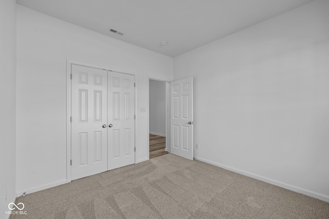 unfurnished bedroom with carpet flooring and a closet