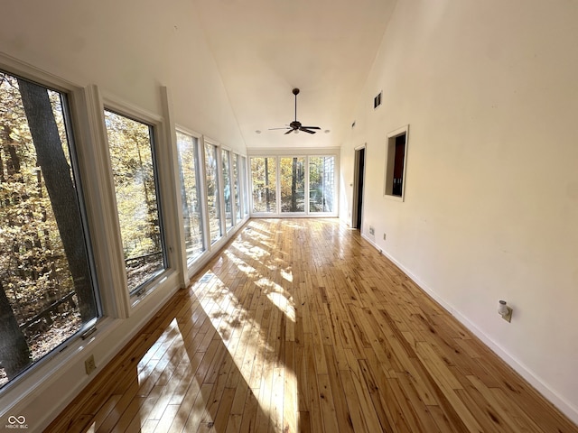 unfurnished sunroom with ceiling fan, lofted ceiling, and a wealth of natural light