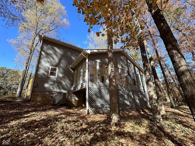 view of property exterior with cooling unit and a sunroom