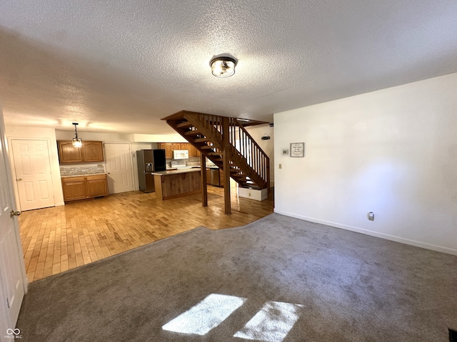 unfurnished living room with a textured ceiling and light colored carpet