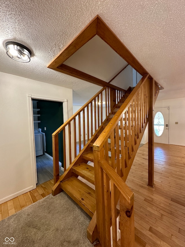 stairway featuring hardwood / wood-style flooring and a textured ceiling