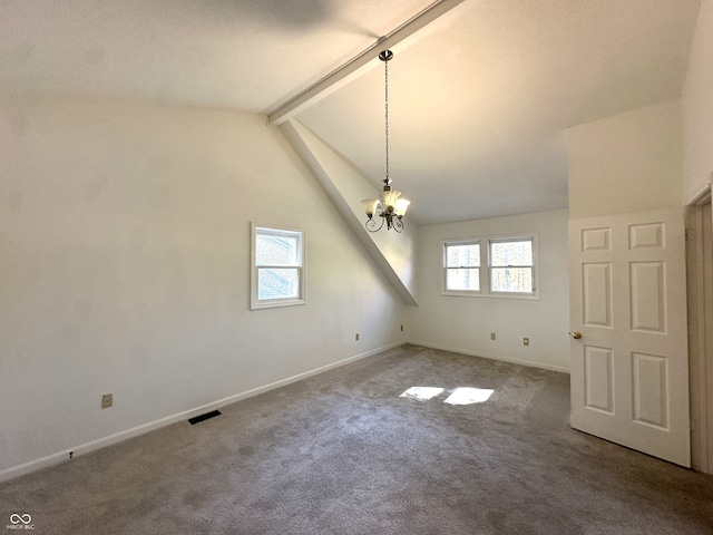 carpeted empty room with lofted ceiling with beams, a wealth of natural light, and a chandelier