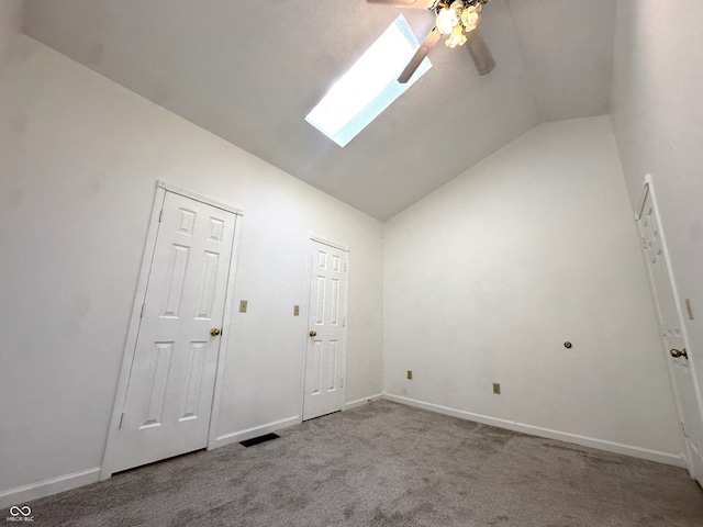 interior space with vaulted ceiling with skylight and ceiling fan