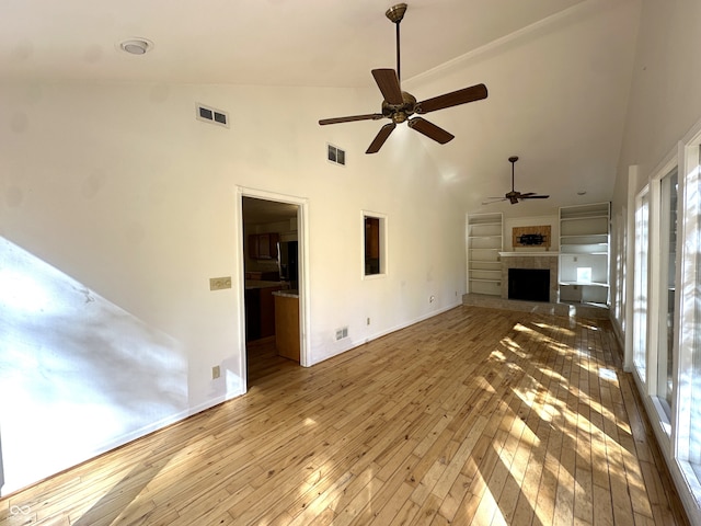 unfurnished living room featuring hardwood / wood-style floors, high vaulted ceiling, a fireplace, and ceiling fan