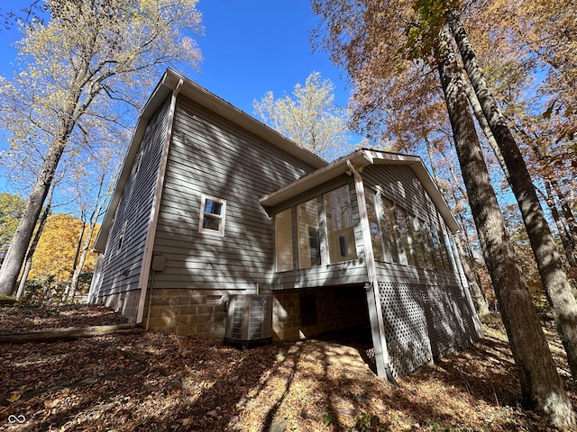 view of home's exterior with cooling unit and a sunroom