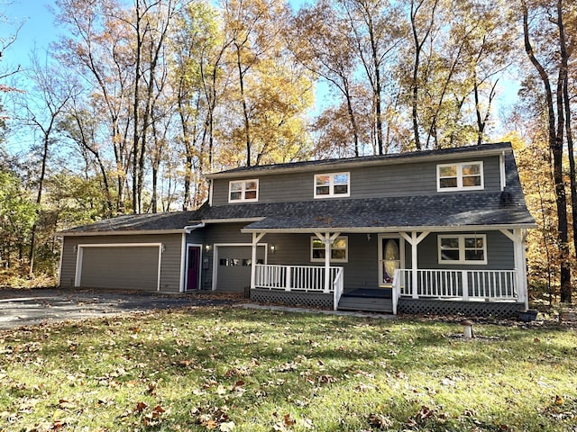 front of property featuring a front yard, covered porch, and a garage