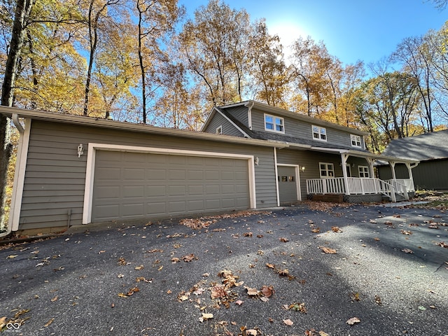 view of property featuring a garage and a porch