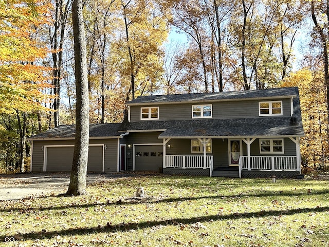 view of front of house with a front yard, covered porch, and a garage