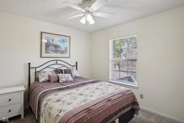 bedroom with a textured ceiling, carpet flooring, and ceiling fan