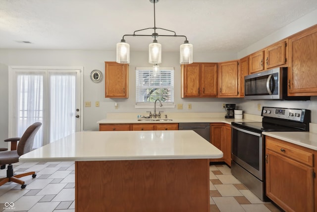 kitchen featuring appliances with stainless steel finishes, sink, a kitchen island, and hanging light fixtures