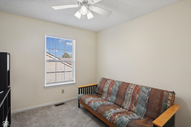 living area featuring light colored carpet and ceiling fan