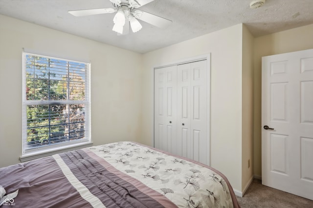 bedroom featuring a closet, ceiling fan, carpet flooring, and a textured ceiling