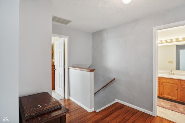 interior space featuring hardwood / wood-style floors, sink, and a textured ceiling