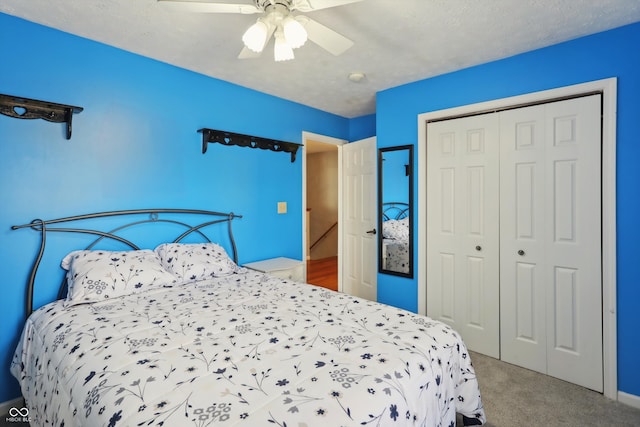 carpeted bedroom featuring a closet, ceiling fan, and a textured ceiling