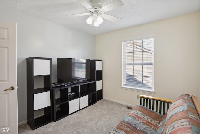 sitting room featuring light colored carpet and ceiling fan