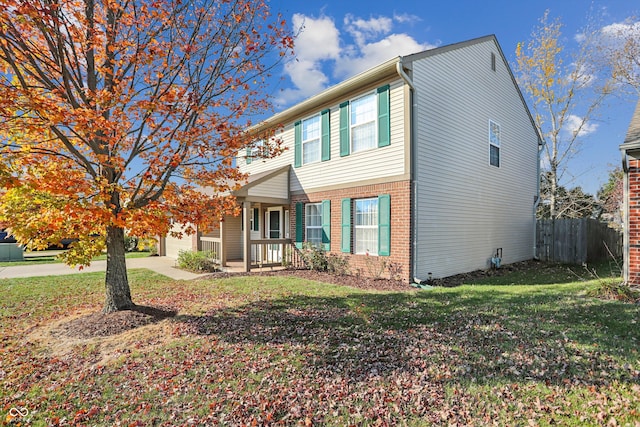 view of front facade with covered porch, a front yard, and a garage