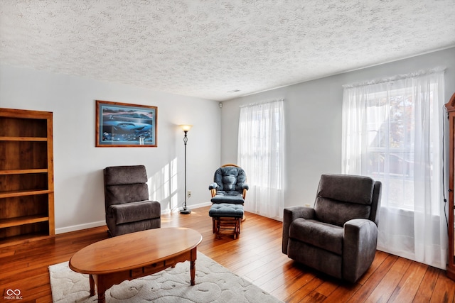 sitting room with a textured ceiling, a healthy amount of sunlight, and wood-type flooring