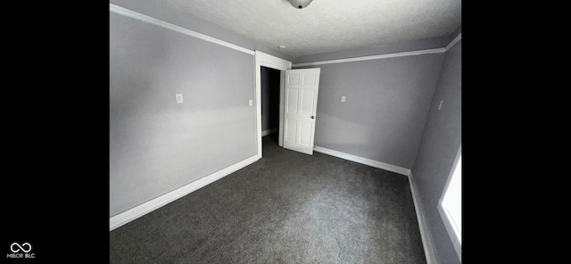 unfurnished bedroom with a textured ceiling and dark carpet